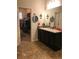 Bathroom featuring dual sinks, dark cabinets, and a walk-in closet for ample storage at 3173 Youngheart Way, Castle Rock, CO 80109