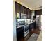 Close-up of a kitchen with stainless steel appliances and dark wood cabinets at 3173 Youngheart Way, Castle Rock, CO 80109