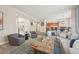 Open-concept living room featuring comfortable seating, a rustic coffee table, and seamless flow to the kitchen at 11623 E Ida Ave, Englewood, CO 80111