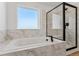 Modern bathroom featuring marble wall and floor tiles, soaking tub, and a glass enclosed shower at 42992 Colonial Trl, Elizabeth, CO 80107