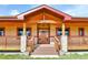Inviting front porch with stone pillars and a stained wood front door at 5365 Eldridge St, Arvada, CO 80002