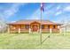Ranch style home with covered porch, stone accents, and mature lawn at 5365 Eldridge St, Arvada, CO 80002