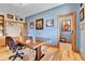 A spacious home office with wooden floors, a custom wood desk, and multiple entryways at 5365 Eldridge St, Arvada, CO 80002