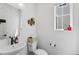 Chic half bathroom features a pedestal sink, patterned wallpaper, and natural light at 175 Westerly Blvd, Erie, CO 80516