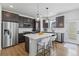 Modern kitchen featuring dark cabinets, stainless steel appliances, and a quartz island with seating at 175 Westerly Blvd, Erie, CO 80516