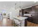 Modern kitchen featuring dark cabinets, stainless steel appliances, and a quartz island with seating at 175 Westerly Blvd, Erie, CO 80516