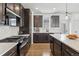 Modern kitchen featuring dark cabinets, stainless steel appliances, and a quartz island with seating at 175 Westerly Blvd, Erie, CO 80516