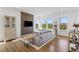 Bright living room features a gray sofa, wood floors, and a modern media wall at 175 Westerly Blvd, Erie, CO 80516