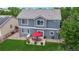 An aerial view highlights the backyard, with a red umbrella, seating area, and green lawn at 19730 E 58Th Pl, Aurora, CO 80019