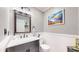 Stylish powder room with gray vanity, decorative mirror, and elegant wall decor at 19730 E 58Th Pl, Aurora, CO 80019