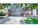 Two car garage on gray home with red accents, landscaped front yard, and covered porch at 19730 E 58Th Pl, Aurora, CO 80019