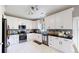 Well-appointed kitchen featuring white cabinets, stainless steel appliances, and sleek black countertops at 19730 E 58Th Pl, Aurora, CO 80019