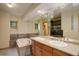 Bathroom showcasing a tub, and dual sink vanity with light wood cabinets at 13190 Coyote Song Trl, Conifer, CO 80433