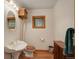 Small bathroom featuring a pedestal sink, wooden accents, and a framed mirror and window at 13190 Coyote Song Trl, Conifer, CO 80433