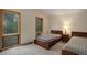 Cozy bedroom with carpet floors featuring two twin beds and view of the forest at 13190 Coyote Song Trl, Conifer, CO 80433