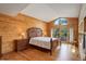 Spacious bedroom featuring a wood paneled accent wall, light hardwood floors, and sliding glass doors to the outside at 13190 Coyote Song Trl, Conifer, CO 80433