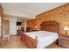 Comfortable bedroom featuring a wood paneled accent wall, light hardwood floors, and a flatscreen television at 13190 Coyote Song Trl, Conifer, CO 80433