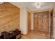 Inviting entryway with wooden walls and floors and a rustic front door with window panes at 13190 Coyote Song Trl, Conifer, CO 80433