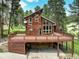 Stunning mountain home featuring a wrap-around deck and convenient drive-under garage at 13190 Coyote Song Trl, Conifer, CO 80433