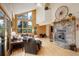 Spacious living room with stone fireplace, vaulted ceilings, and large windows with natural light at 13190 Coyote Song Trl, Conifer, CO 80433