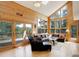 Bright living room boasting wood paneled walls, scenic views, and cozy seating arrangement at 13190 Coyote Song Trl, Conifer, CO 80433