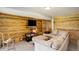 Comfortable living room with wood accent wall, TV, and plush sectional sofa and outside access at 13190 Coyote Song Trl, Conifer, CO 80433
