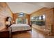 Comfortable bedroom with wood walls, large windows, and access to a private balcony at 13190 Coyote Song Trl, Conifer, CO 80433