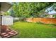 Well-maintained backyard with lush green lawn, bordered by a wooden fence and mature trees at 6874 S Detroit Cir, Centennial, CO 80122