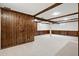 A carpeted finished basement with rustic wood paneling and white support beams at 6874 S Detroit Cir, Centennial, CO 80122