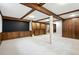 Finished basement with wood-paneled walls, carpet, and exposed ceiling beams at 6874 S Detroit Cir, Centennial, CO 80122