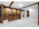 Finished basement showcasing wood paneled accent wall, carpet, and access to stairs at 6874 S Detroit Cir, Centennial, CO 80122