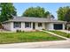 Charming single story house featuring manicured green lawn, rock details, and a two car garage at 6874 S Detroit Cir, Centennial, CO 80122