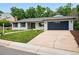 Beautiful exterior showing a well maintained lawn, painted white brick, and two car garage at 6874 S Detroit Cir, Centennial, CO 80122