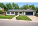 Charming home featuring a well-manicured lawn, painted brick and stone details and an attached two car garage at 6874 S Detroit Cir, Centennial, CO 80122