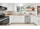 Updated kitchen featuring stainless steel appliances, quartz counters, and open shelving at 6874 S Detroit Cir, Centennial, CO 80122