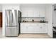 Bright kitchen featuring stainless steel refrigerator, white cabinets, and sleek countertops at 6874 S Detroit Cir, Centennial, CO 80122