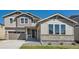 Charming two-story home featuring a stone facade, inviting entrance, and attached two car garage at 4599 Windmill Dr, Brighton, CO 80601