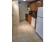 Kitchen includes tile floors, white appliances, oak cabinets and red accent wall at 10211 Ura Ln # 2-201, Thornton, CO 80260