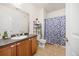 Clean bathroom with a vanity sink, neutral tiling, and a shower with a curtain at 4100 Albion St # 612, Denver, CO 80216