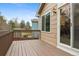Spacious wooden deck with railing, sliding glass doors, and backyard views at 6425 Nassau Ct, Highlands Ranch, CO 80130