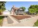 Exterior shot showing the front of the house with a detached garage and gravel driveway at 3755 S Sherman St, Englewood, CO 80113
