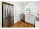 Bright kitchen features stainless steel appliances, quartz countertops, white cabinets, and wood floors at 3755 S Sherman St, Englewood, CO 80113