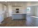 Bright kitchen with white cabinets, stainless steel appliances, an island, and hardwood floors at 3911 N Shawnee St, Aurora, CO 80019