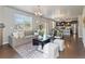 Bright living room with comfortable seating, a large window, hardwood floors, and an open layout flowing into the kitchen at 1181 W 170 Th Ave, Broomfield, CO 80023