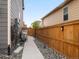 Narrow side yard with gravel landscaping and a wooden fence, providing a defined boundary between properties at 1181 W 170 Th Ave, Broomfield, CO 80023