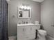 Bathroom with a white vanity, framed mirror, new lighting and a shower curtain at 8233 W 62Nd Pl, Arvada, CO 80004