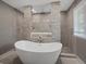 Spa-like bathroom featuring a soaking tub, stone accents, and modern fixtures at 8233 W 62Nd Pl, Arvada, CO 80004