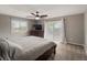 Cozy bedroom with a large bed, dresser, walk out balcony, and a ceiling fan at 8233 W 62Nd Pl, Arvada, CO 80004