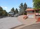 Home exterior featuring an RV parked on a driveway with mature trees and a brick facade at 8233 W 62Nd Pl, Arvada, CO 80004