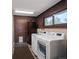 Laundry room with brick walls, modern washer and dryer, and ample storage space at 8233 W 62Nd Pl, Arvada, CO 80004